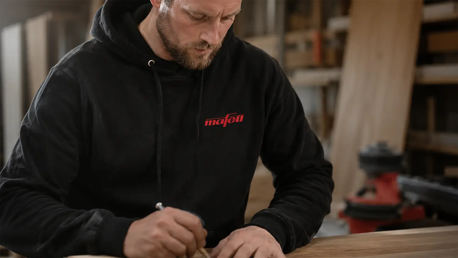 Mann mit schwarzem Mafell Hoodie in der Werkstatt